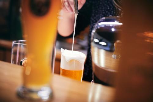 a person is sitting at a table with a glass of beer at Gasthof Mittendorfer in Haag am Hausruck