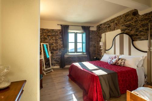 a bedroom with a bed and a stone wall at Angiolina's Farm in Levanto
