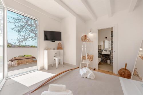 a living room with white walls and a large window at Cala Cala Rooms,Restaurant & Farm Experience in Procida