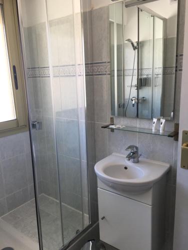 a bathroom with a sink and a glass shower at VOLTA in Bastia