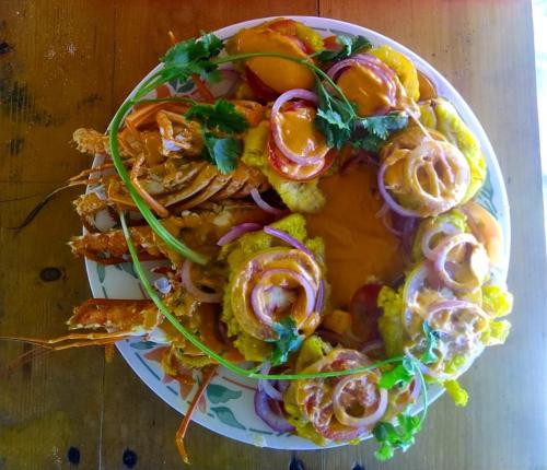 a plate of food with vegetables on a table at Urantia Beach Hostel & Surf Camp in San Onofre