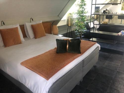 a large bed with two pillows on it in a room at De Weideblom in Schermerhorn