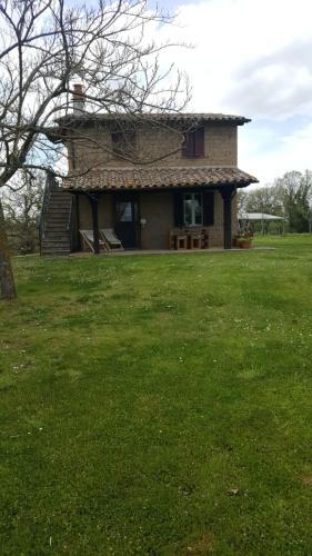 a house in a field with a grass yard at Agriturismo Podernuovo in Acquapendente