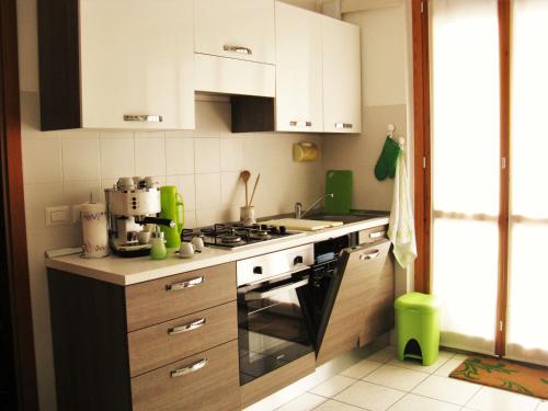 a kitchen with white cabinets and a stove top oven at Conero Green Homes in Porto Recanati