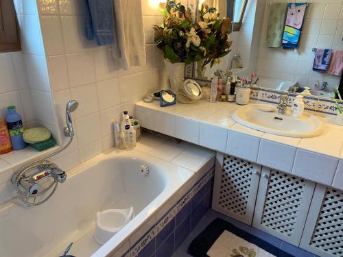 a bathroom with a tub and a sink at Siusi Sciliar Apartment in Siusi