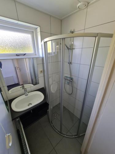 un baño con ducha y lavabo en De Duinrand, en Oostkapelle