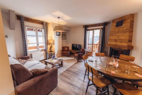 uma sala de estar com uma mesa e um sofá em Chalet La Fedora - Appartements de charme em Vaujany