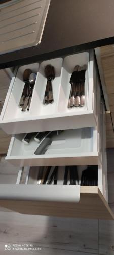 a white shelf with silver utensils on it at Apartmán Paula 3 in Podhájska