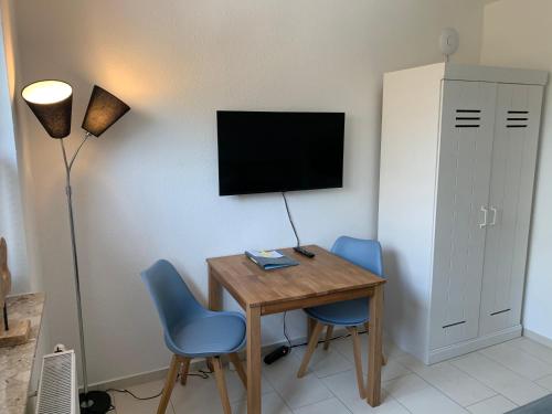 a room with a desk and two chairs and a television at Ostwind - ferienwohnungen & meer in Steffenshagen