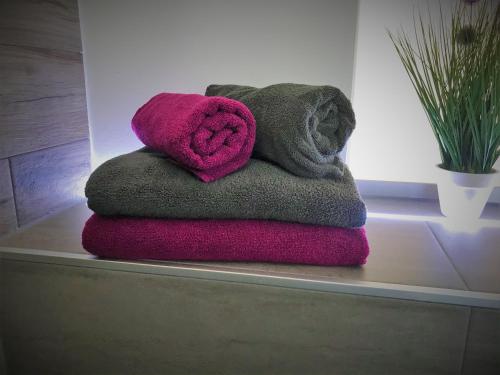 a pile of towels sitting on a shelf in a bathroom at SALZHAUSBLICK FAMILY APARTMENTS - Zentrale Lage am Salzhaus - MwSt-Rechnung verfügbar in Zittau