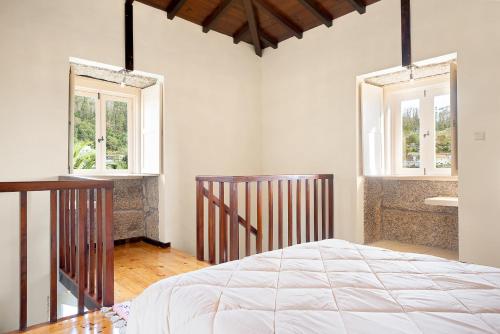 1 dormitorio con 1 cama y 2 ventanas en Quinta dos Campos - Chalé, en Braga