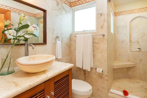 a bathroom with a sink and a toilet and a shower at Porto Playa Condo Hotel and Beach Club in Playa del Carmen