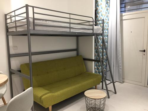 un lit mezzanine avec un canapé vert dans une chambre dans l'établissement Premier logement, à Montpellier