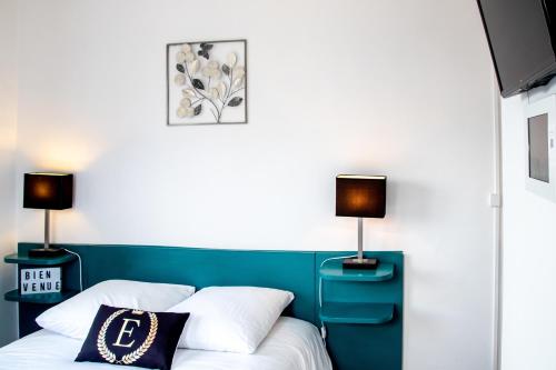 a bedroom with a bed with two lamps on it at Hôtel & Gastronomie - La Table de l'Europe in Villeréal