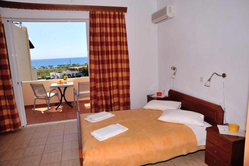 a bedroom with a bed with a view of a balcony at Anemoni Studios in Plakias