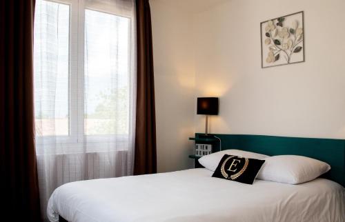 a bedroom with a bed with a window and a pillow at Hôtel & Gastronomie - La Table de l'Europe in Villeréal