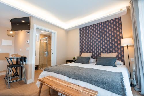 a bedroom with a large bed and a table at Apartamentos Kai in Getxo