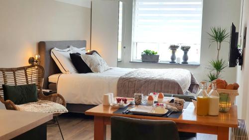 a bedroom with a bed and a table with at B&Be Happy in Berg en Terblijt