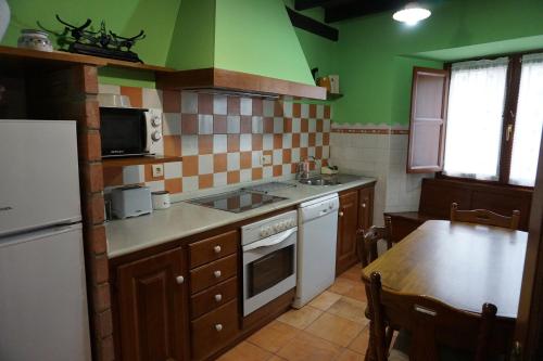 a kitchen with a white refrigerator and a table at Casa Rural Moradiellos in Arenas de Cabrales