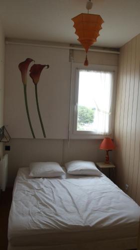 - une chambre avec un lit avec deux oreillers et une fenêtre dans l'établissement Appartement T3 Vue sur mer, à Saint-Jean-de-Monts