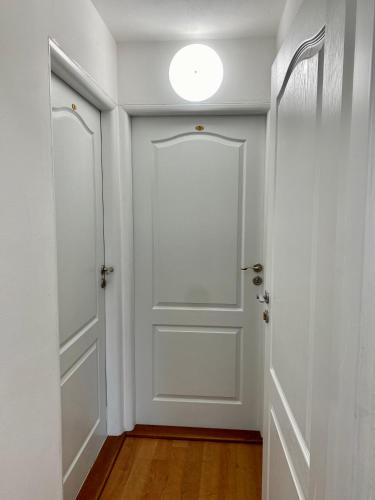 an empty hallway with a white door and a light at Chalupa Synka in Terchová