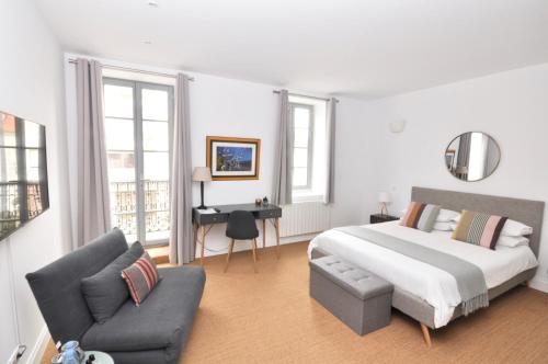 a white bedroom with a bed and a couch at Les Tourelles in Biarritz