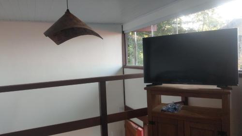 a flat screen tv sitting on a stand next to a window at Mi casa Su casa Lofts - LOFT 5 in Angra dos Reis