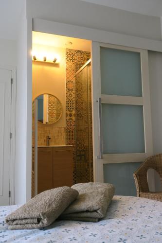 La salle de bains est pourvue d'une douche avec un miroir et d'un lit. dans l'établissement Vagabondes chambres d'hôtes, à Azay-le-Rideau