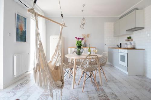 a white kitchen with a table and chairs in a room at Randez-View - 60 m2, widok na jezioro z tarasu, duży taras, klima, parking, Netflix in Iława