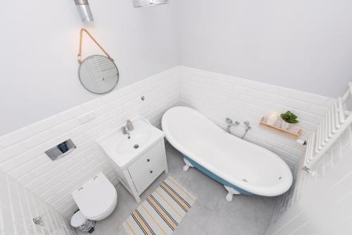 La salle de bains est pourvue d'une baignoire, d'un lavabo et de toilettes. dans l'établissement Randez-View Apartment, à Iława
