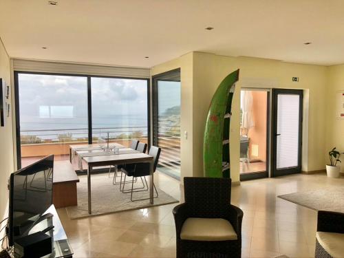 a dining room with a table and a view of the ocean at Luxus Ferienhaus Casa Paraiso in Sesimbra