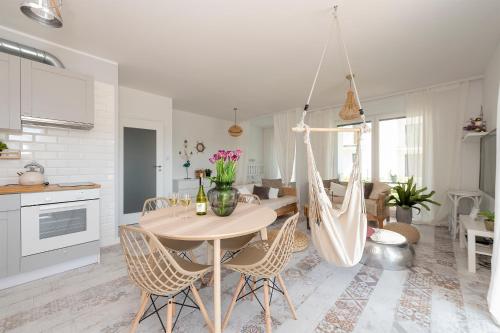 Il comprend une cuisine et un salon avec une table et des chaises. dans l'établissement Randez-View Apartment, à Iława