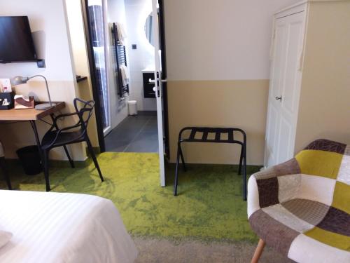 a room with a bed and a desk and a chair at Hotel Restaurant au Floridor in Thann