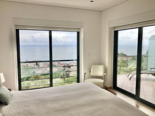 una camera con letto e vista sull'oceano di Luxus Ferienhaus Casa Paraiso a Sesimbra