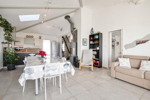 une salle à manger blanche avec une table et un canapé dans l'établissement Villa Lavande, à Yves