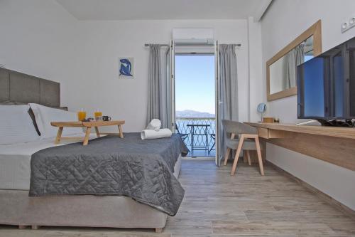een slaapkamer met een bed en een televisie en een tafel bij Vidos Seaview Suite in Corfu-stad