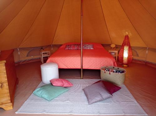 a room with a bed and pillows in a tent at Terre del Piano-Bell Tent in Corinaldo