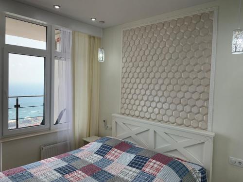 1 dormitorio con cama y ventana en Терраса с панорамой моря в Аркадии, en Odessa