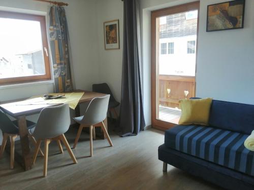 ein Wohnzimmer mit einem Sofa und einem Tisch mit Stühlen in der Unterkunft Haus Sonja in Lermoos