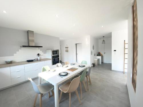 a kitchen and dining room with a white table and chairs at Belle maison de 140m2, proche centre ville in Challans