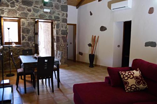 een woonkamer met een rode bank en een tafel bij El Rinconcito de Tejeda in Tejeda