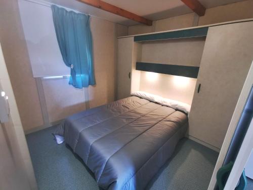 カルバージョにあるBungalow As Nevedasの小さなベッドルーム(ベッド1台、青いカーテン付)