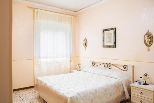 トラーパニにあるLa casa di Maryの白いベッドルーム(ベッド1台、窓付)
