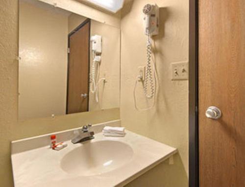 een badkamer met een wastafel, een spiegel en een douche bij Super 8 by Wyndham Ruther Glen Kings Dominion Area in Ruther Glen
