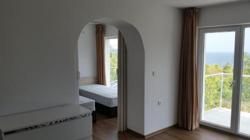 Habitación con espejo, cama y ventana en Villa Princess Maria, en Balchik