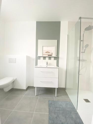 a white bathroom with a sink and a toilet at Belle maison de 140m2, proche centre ville in Challans