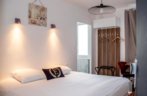 a bedroom with a white bed with a pillow on it at Hôtel & Gastronomie - La Table de l'Europe in Villeréal