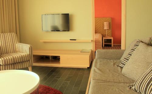 sala de estar con sofá y TV de pantalla plana en Kaluri Residence, en Kuressaare