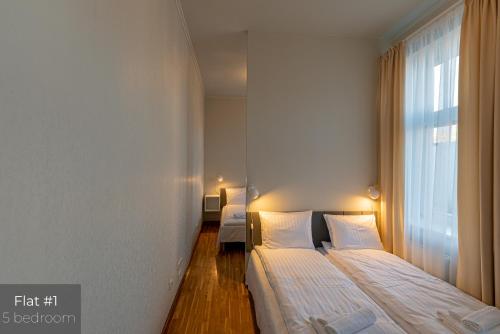 a bedroom with two beds and a window at Dandelion Apartments XIXc Cottage in Rīga