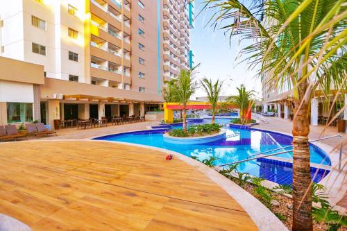 a pool in the middle of a building with a palm tree at OLIMPIA PARK RESORTs "MELHOR PREÇO " in Olímpia